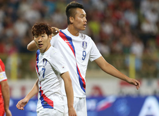 Korean national football team winger Son Heung-min, left, and striker Kim Shin-wook pass each other during a friendly against Russia at Zabeel Stadium in Dubai, Wednesday (KST). Korea lost 2-1. / Yonhap