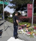 Students view a growing memorial at Seattle Pacific University near Otto Miller Hall Friday, June 6, 2014 in Seattle, where a fatal shooting took place Thursday afternoon. (AP Photo/Ted S. Warren)