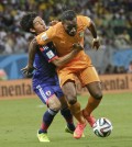 Japan's Masato Morishige, left, tries to hold Ivory Coast's Didier Drogba, right, during the group C World Cup soccer match at the Arena Pernambuco in Recife, Brazil, Saturday, June 14, 2014. (AP Photo/Petr David Josek)