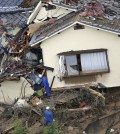 In this aerial photo, rescue workers search for survivors in an area devastated by a massive landslide which swept through residential areas in Hiroshima, western Japan, Wednesday, Aug. 20, 2014. A several people died and at least a dozen were missing after rain-sodden hills in the outskirts of Hiroshima gave way early Wednesday in several landslides. (AP Photo/Kyodo News)