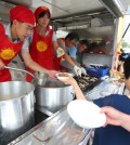 Animal activists from the Korea Animal Rights Advocates (KARA) and officials of the Seoul Metropolitan Government hand out bowls of vegetable soup to citizens on Cheonggye Plaza in Gwanghwamun, central Seoul, Tuesday. They are promoting health food made of vegetables instead of meats ahead of "malbok," the last of the three hottest periods of the summer on the lunar calendar, which falls on Aug. 12. (Yonhap)