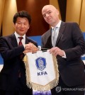 FIFA President Gianni Infantino (R) and Korea Football Association (KFA) President Chung Mong-gyu hold the KFA pennant during a press conference in Seoul on April 27, 2016.