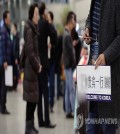 A tour guide waits for Chinese group travelers with a welcome sign in his hand at Incheon International Airport, west of Seoul, on March 3, 2017. (Yonhap)