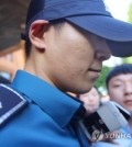 South Korean singer and actor T.O.P. of boy band BIGBANG, who is serving his mandatory military service as a conscripted policeman, leaves his workplace in Seoul surrounded by reporters questioning his marijuana charges on June, 5, 2017. (Yonhap)