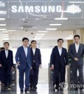 Finance Minister Kim Dong-yeon (2nd from R) talks with Samsung Electronics Vice Chairman Lee Jae-yong (R) while moving into a room for talks at the tech giant's chipmaking line in Pyeongtaek, south of Seoul, on Aug. 6, 2018. (Yonhap)