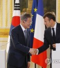 South Korean President Moon Jae-in (L) and French President Emmanuel Macron shake hands after holding a joint press conference to explain the outcome of their bilateral summit held at the Elysee Palace in Paris on Oct. 15, 2018. (Yonhap)