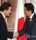 This photo, taken on Sept. 11, 2018, shows South Korean Prime Minister Lee Nak-yon (L) shaking hands with Japanese Prime Minister Shinzo Abe during a meeting on the sidelines of the 4th Eastern Economic Forum in Vladivostok, Russia. (Yonhap)