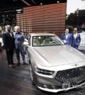 Genesis executives, from left, Erwin Raphael, Luc Donckerwolke, William Lee, and Mark Del Rosso pose for pictures with the G90 at the AutoMobility LA auto show Wednesday, Nov. 20, 2019, in Los Angeles. (AP Photo/Marcio Jose Sanchez)