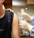 This file photo shows a young person getting vaccinated against COVID-19. (Yonhap)