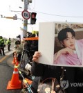 (ATTN: UPDATES with more information, message from Jin in paras 6, 12-15, 24-25)

SEOUL, Dec. 13 (Yonhap) -- K-pop superstar Jin on Tuesday entered a boot camp in a front-line area to begin his mandatory military service, with hundreds of reporters from domestic and foreign news media waiting outside to cover the news.

The 30-year-old became the first member of the boy band BTS to join the military. The group's six other members -- RM, Suga, Jimin, J-hope, V and Jungkook -- will also be enlisting in the military in order, according to the band's agency, Big Hit Music.

The vocalist quietly entered an Army training center in Yeoncheon, 60 kilometers north of Seoul, in a car without a farewell event for fans.

Journalists and BTS fans gather outside of an army training camp in Yeoncheon, 60 kilometers north of Seoul, to see Jin, a vocalist of the band, on Dec. 13, 2022. (Yonhap)