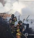 Firefighters battle a fire in the fourth district of Guryong Village, the last remaining slum in Seoul, in the capital's Gangnam Ward on Jan. 20, 2023. (Yonhap)