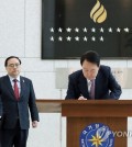 President Yoon Suk Yeol (R) signs a guest book during a visit to the National Intelligence Service headquarters in Seoul on Feb. 24, 2023, in this photo provided by the presidential office. (PHOTO NOT FOR SALE) (Yonhap)