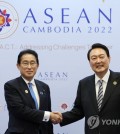 This file photo shows South Korean President Yoon Suk Yeol (R) and Japanese Prime Minister Fumio Kishida posing for a photo prior to their talks in Phnom Penh, Cambodia, in November, 2022. Seoul's presidential office announced on March 9, 2023, that Yoon will visit Japan from March 16-17 for summit talks with Kishida. (Yonhap)