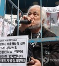 Park Kyoung-seok, the 63-year-old leader of the Solidarity Against Disability Discrimination (SADD), speaks inside a cage during a press conference in Seoul on March 17, 2023, before police arrested him on illegal demonstration charges. (Yonhap)