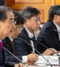 Prime Minister Han Duck-soo (L) speaks while presiding over a government meeting at the government complex in Seoul on April 12, 2023, to discuss combating school violence. (Yonhap)