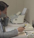 This file photo, provided by the unification ministry, shows a South Korean liaison officer talking to his North Korean counterpart at the Seoul bureau of their joint liaison office on Oct. 4, 2021. After a two-month suspension, the two Koreas restored cross-border communication lines that Pyongyang suspended in protest against an annual combined military exercise of South Korea and the United States. (PHOTO NOT FOR SALE) (Yonhap)