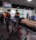 A student is moved to a hospital due to breathing difficulty after an airplane landed with a door open at Daegu International Airport on May 26, 2023. (Yonhap)