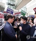 A police investigator shows his ID before protesting labor union members of MBC at the broadcasting network's headquarters in western Seoul on May 30, 2023. (Yonhap)