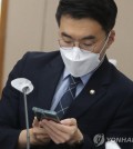 Rep. Kim Nam-kuk, a former member of the main opposition Democratic Party, checks his smartphone during a parliamentary inspection in Daejeon, 139 kilometers south of Seoul, on May 14, 2023. (Yonhap)