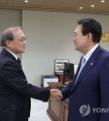 President Yoon Suk Yeol (R) shakes hands with Takeo Akiba, secretary general of Japan's National Security Secretariat, at his office in Seoul on May 3, 2023, in this photo provided by the presidential office. (PHOTO NOT FOR SALE) (Yonhap)