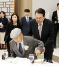 President Yoon Suk Yeol helps his former high school teacher Choi Yun-bok take a seat during a luncheon at the presidential office in Seoul on May 15, 2023. (Pool photo) (Yonhap)