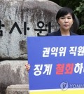 Jeon Hyun-heui, chairperson of the Anti-Corruption and Civil Rights Commission (ACRC), holds a placard demanding the Board of Audit and Inspection (BAI) withdraw its disciplinary action against an ACRC worker, in front of the BAI's building in Seoul, on June 9, 2023. (Yonhap)