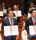 Ruling People Power Party lawmakers pose for a photo at the National Assembly in Seoul on June 21, 2023, while holding their oath to give up their immunity from arrest.