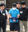 A 33-year-old suspect (C) in a fatal stabbing rampage is taken to the Seoul Central District Court on July 23, 2023, to attend a hearing on his arrest warrant. (Yonhap)