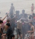 Participants of the 25th World Scout Jamboree enjoy the Mud Mob-Scene festival at Daecheon Beach in Boryeong, central western South Korea, on Aug. 9, 2023. (Yonhap)