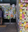 Post-it messages commemorating a school teacher who died cover an entrance and outer wall of an elementary school in southern Seoul on July 26, 2023. (Yonhap)