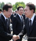 President Yoon Suk Yeol (R) shakes hands with opposition leader Lee Jae-myung at a Memorial Day event at Seoul National Cemetery in Seoul in this file photo taken June 6, 2023. (Yonhap)