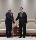 President Yoon Suk Yeol (R) shakes hands with Piotr Hofmanski, chief of the International Criminal Court, ahead of their meeting at South Korea's presidential office in Seoul on Nov. 13, 2023, in this photo provided by Yoon's office. (PHOTO NOT FOR SALE) (Yonhap)