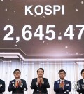 President Yoon Suk Yeol (C) claps after pressing a button signaling the start of trading on the first trading day of the new year at the Seoul office of the Korea Exchange on Jan. 2, 2023. (Yonhap)