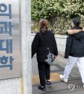 Two people walk through the gate of a medical school in Seoul on Feb. 4, 2024. (Yonhap)