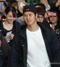 Shohei Ohtani of the Los Angeles Dodgers (C) walks toward an exit at Incheon International Airport, west of Seoul, on March 15, 2024, after arriving from the United States to prepare for Major League Baseball's Seoul Series. Trailing Ohtani is his wife, Mamiko Tanaka (L). (Yonhap)