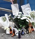 Flowers and drinks are left in memory of the victims of a car accident in downtown Seoul on July 3, 2024. A car crashed into pedestrians waiting for traffic signals at an intersection in downtown Seoul two days earlier, leaving nine dead and seven others injured. (Yonhap)