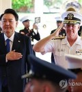 President Yoon Suk Yeol (L) and Adm. Samuel Paparo, commander of the Indo-Pacific Command, salute their countries' national flags during Yoon's visit to Camp Smith, the command's headquarters in Hawaii, on July 9, 2024. (Yonhap)