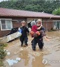 This photo, provided by fire authorities, shows rescuers evacuating a villager in Wanju on July 10, 2024. (PHOTO NOT FOR SALE) (Yonhap)