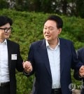 President Yoon Suk Yeol (C), People Power Party Chairman Han Dong-hoon (L) and PPP floor leader Choo Kyung-ho hold hands for a photo during dinner at the presidential compound in Seoul on July 24, 2024, in this photo provided by the presidential office. (PHOTO NOT FOR SALE) (Yonhap)