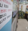 A pharmacy in Seoul puts up a notice on COVID-19 treatments on Aug. 11, 2024. (Yonhap)