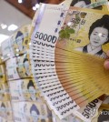 A clerk checks 50,000-won notes at a Seoul bank on July 17, 2024. (Yonhap)