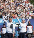 Kim Woo-jin (L) and Lim Si-hyeon of South Korea celebrate their victory over Germany in the archery mixed team final at the Paris Olympics at Invalides in Paris on Aug. 2, 2024. (Yonhap)