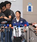 South Korean badminton player An Se-young (C) speaks with reporters at Incheon International Airport, west of Seoul, on Aug. 7, 2024, after returning home with the women's singles gold medal from the Paris Olympics. (Yonhap)