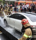 Firefighters extinguish an electric vehicle fire during a drill at an apartment complex in Busan on Aug. 27, 2024, following a recent series of similar incidents. (Yonhap)