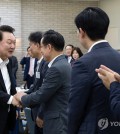 President Yoon Suk Yeol (L) shakes hands with a lawmaker of the ruling People Power Party (PPP) during a dinner meeting with the PPP leadership at the presidential office in Seoul on Oct. 2, 2024, in this photo provided by Yoon's office. (PHOTO NOT FOR SALE) (Yonhap)