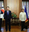 Choi Sang-mok (L), South Korea's finance minister and deputy prime minister, and Alcenio Barisakan (R), Secretary of the National Economic and Development Authority of the Philippines, exchange a memorandum of understanding on the Economic Innovation Partnership Program at the Malacanang Palace in Manila on Oct. 7, 2024. South Korean President Yoon Suk Yeol (2nd from L) and Philippine President Ferdinand Marcos Jr. attended the ceremony. (Yonhap)