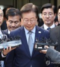 Opposition leader Lee Jae-myung (C) answers reporters' questions outside the Seoul Central District Court in southern Seoul on Nov. 15, 2024, after the court sentenced him to a suspended one-year prison term for lying during the 2022 presidential election campaign. (Yonhap)