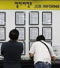 This Sept. 11, 2024, file photo shows jobseekers checking job postings at an employment center in Seoul. (Yonhap)