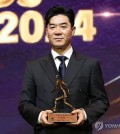 In this file photo from Nov. 29, 2024, Yoon Jong-hwan, then head coach of Gangwon FC, poses with the trophy as the Coach of the Year for the 2024 K League 1 season during the K League Awards ceremony at Swiss Grand Hotel in Seoul. Gangwon FC announced on Dec. 6 that they parted ways with Yoon. (Yonhap)