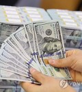 This file photo taken Dec. 19, 2024, shows a clerk checking U.S. dollar notes at a center of Hana Bank in Seoul. (Yonhap)